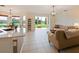 Open-concept living area with tile flooring, neutral decor and great natural light overlooking the screened-in patio at 1976 The Oaks Blvd, Kissimmee, FL 34746