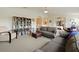 Bright living room with neutral carpet, gray sofa, ottoman, and a bookshelf stocked with books at 1976 The Oaks Blvd, Kissimmee, FL 34746