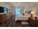 Well-lit main bedroom featuring wood floors, a chandelier, dresser, and access to the backyard at 1976 The Oaks Blvd, Kissimmee, FL 34746