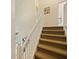 Carpeted staircase featuring a white handrail and a view of the lower level at 1976 The Oaks Blvd, Kissimmee, FL 34746