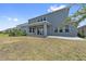 Rear exterior showcasing a large yard, covered patio, and multiple windows at 2110 Old Hollow Ln, Clermont, FL 34715