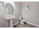 Bathroom with pedestal sink, decorative round mirror, wood-look flooring at 2110 Old Hollow Ln, Clermont, FL 34715