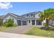 Charming two-story home featuring a three-car garage, brick driveway, and well-manicured lawn at 2110 Old Hollow Ln, Clermont, FL 34715