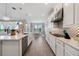 Long kitchen with white cabinets, stainless appliances and an adjacent dining area at 2110 Old Hollow Ln, Clermont, FL 34715