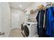Laundry room featuring modern washer and dryer with overhead storage and wood-look tile at 2110 Old Hollow Ln, Clermont, FL 34715