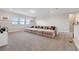 Carpeted upstairs living area with long sectional sofa and natural light at 2110 Old Hollow Ln, Clermont, FL 34715