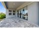 Covered patio with stone flooring, sliding glass doors, and a view of the landscaped backyard at 2110 Old Hollow Ln, Clermont, FL 34715