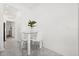 Bright dining area features a glass table, seating for four, and modern decor; view to a bedroom and hall at 2156 Merrybells Dr, Kissimmee, FL 34746