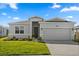 Charming single-story home featuring a well-manicured lawn and a two-car garage at 2156 Merrybells Dr, Kissimmee, FL 34746