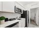 Modern kitchen with stainless steel appliances, white cabinetry and quartz countertops at 2156 Merrybells Dr, Kissimmee, FL 34746