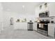Bright, open kitchen boasts stainless steel appliances and modern white cabinets at 2156 Merrybells Dr, Kissimmee, FL 34746