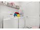 Functional laundry room with a washing machine, dryer, and storage shelves at 2156 Merrybells Dr, Kissimmee, FL 34746
