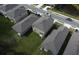 Aerial view of a residential area with neat lawns, modern homes, and cars parked on a street near a pond at 2189 Teneroc Trl, Lakeland, FL 33801