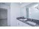 Bright bathroom featuring a double sink vanity with a granite countertop, a large mirror, and a shower at 2189 Teneroc Trl, Lakeland, FL 33801