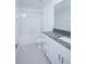 Well-lit bathroom features a granite countertop, white cabinets, and a shower over the tub at 2189 Teneroc Trl, Lakeland, FL 33801