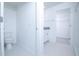 Bright bathroom featuring a white vanity with granite countertop and tiled floor, leading to a walk-in closet at 2189 Teneroc Trl, Lakeland, FL 33801