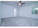 Spacious bedroom featuring a ceiling fan, neutral carpeting, and abundant natural light at 2189 Teneroc Trl, Lakeland, FL 33801
