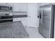 Granite countertops highlight the stainless steel appliances, and white cabinets of this kitchen at 2189 Teneroc Trl, Lakeland, FL 33801