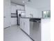 Kitchen island with stainless steel dishwasher surrounded by white cabinets and granite countertop at 2189 Teneroc Trl, Lakeland, FL 33801