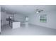 Bright, open-concept living room with white tile, island kitchen, and sliding door to screened in porch at 2189 Teneroc Trl, Lakeland, FL 33801
