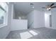 Upstairs loft area with neutral carpet, white walls, staircase with railing, and lots of natural light at 2189 Teneroc Trl, Lakeland, FL 33801