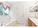 Bathroom featuring a bathtub, a window, and a vanity with double sinks at 253 Aldridge Ln, Davenport, FL 33897