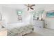 Bright bedroom featuring a ceiling fan, a comfortable bed, and a dresser with an attached mirror at 253 Aldridge Ln, Davenport, FL 33897