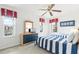 Bright bedroom features twin beds with blue and white striped bedding, creating a playful and inviting space for children at 253 Aldridge Ln, Davenport, FL 33897
