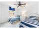 Bright bedroom features twin beds with blue and white striped bedding, creating a playful and inviting space for children at 253 Aldridge Ln, Davenport, FL 33897