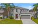 Two-story home with neutral paint, attached two-car garage and mature palm trees enhancing the front yard at 253 Aldridge Ln, Davenport, FL 33897