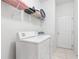 Laundry room with a washer, a dryer, and a shelf for storing laundry supplies at 253 Aldridge Ln, Davenport, FL 33897