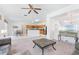 Open-concept living room featuring plush carpeting, ceiling fan and adjacent kitchen with stainless steel appliances at 253 Aldridge Ln, Davenport, FL 33897