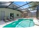 Enclosed in-ground pool with hot tub, lounge chairs, and seating area at 253 Aldridge Ln, Davenport, FL 33897