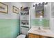 Bathroom with mint green tile surround, built in wall storage, and bright light fixtures at 3122 Eleuthera Ln, Orlando, FL 32827