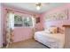 Inviting bedroom with pink walls, terrazzo floors and natural light from a large window at 3122 Eleuthera Ln, Orlando, FL 32827