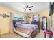 This bedroom features a ceiling fan, natural light, neutral colored walls, and a colorful bed at 3122 Eleuthera Ln, Orlando, FL 32827
