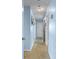 Light-filled hallway with terrazzo flooring that connects the main areas of the home at 3122 Eleuthera Ln, Orlando, FL 32827