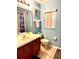 Charming bathroom featuring a single vanity, toilet, and shower with a Mickey Mouse curtain at 314 Saddle Ridge Dr, Davenport, FL 33896