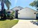 Charming single-Gathering home featuring a well-manicured lawn, inviting entrance, and attached two-car garage at 314 Saddle Ridge Dr, Davenport, FL 33896