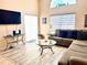 Cozy living room with a sectional sofa, large window, and modern furnishings, ideal for relaxation and entertainment at 314 Saddle Ridge Dr, Davenport, FL 33896