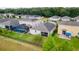 Aerial view of a backyard featuring a screened-in pool, lush green grass, and a black fence at 3298 Stratton Cir, Kissimmee, FL 34744