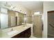 Bathroom features a double sink vanity, a large mirror, and walk-in shower at 3298 Stratton Cir, Kissimmee, FL 34744