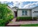 Inviting front entrance with a red door, brick pathway, and lush landscaping with manicured bushes at 3298 Stratton Cir, Kissimmee, FL 34744
