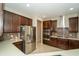 Modern kitchen featuring stainless steel appliances, dark wood cabinetry, and a stylish backsplash at 3298 Stratton Cir, Kissimmee, FL 34744