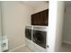 Convenient laundry room featuring a washer, dryer, and upper cabinets for storage at 3298 Stratton Cir, Kissimmee, FL 34744