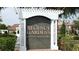 Community sign for Regency Gardens Condominiums with lush landscaping and mature trees at 4301 Lizshire Ln # 306, Orlando, FL 32822