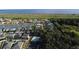 Aerial view of a neighborhood with homes near a lake and community pool surrounded by greenery at 4337 Summer Breeze Way, Kissimmee, FL 34744