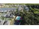 Aerial view of homes in a quiet neighborhood with a community pool surrounded by lush trees at 4337 Summer Breeze Way, Kissimmee, FL 34744