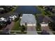 Aerial view of home with brick driveway and two-car garage, backing onto a tranquil lake at 4337 Summer Breeze Way, Kissimmee, FL 34744