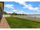 Scenic backyard with a lake view, brick-paved patio, and white picket fence at 4337 Summer Breeze Way, Kissimmee, FL 34744